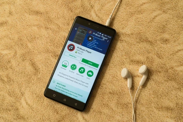 London, 14. November 2017: Pi-Musik-Player-Anwendung im Google Play Store auf sandigem Hintergrund und Kopfhörer — Stockbild Pi Musik-Player-Anwendung in Google Play Store auf sandigem Hintergrund und Kopfhörer — Stockfoto