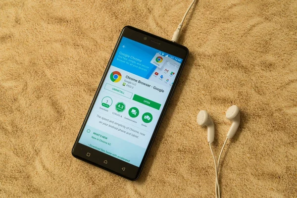 Aplicación de Google Chrome en Google Play Store sobre fondo arenoso y auriculares — Foto de Stock