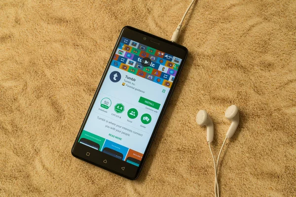 Aplicación Tumblr en Google Play Store sobre fondo arenoso y auriculares — Foto de Stock