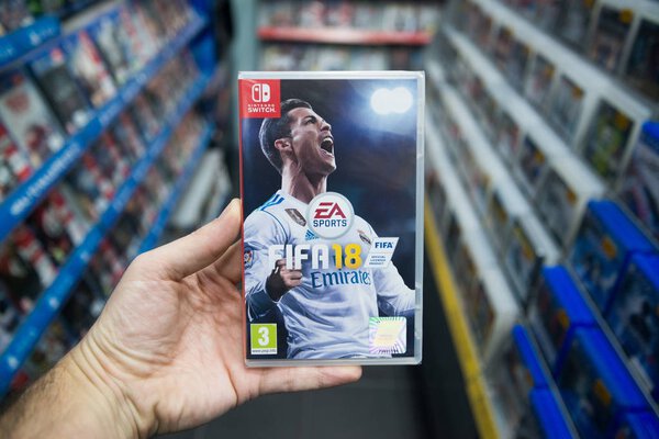 Bratislava, Slovakia, december 2, 2017: Man holding Fifa 18 videogame on Nintendo Switch console in store
