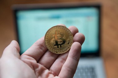 Bitcoin laptop önünde tutan adam