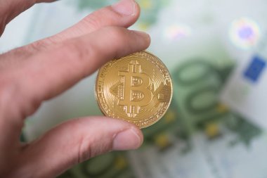 Bitcoin yüz euro faturaları arka plan ile tutan adam