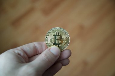 Bitcoin ahşap arka plan ile tutan adam