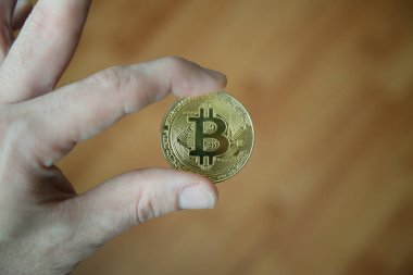 Bitcoin ahşap arka plan ile tutan adam