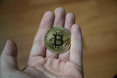 Bitcoin ahşap arka plan ile tutan adam