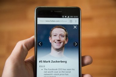 Londra, 31 Aralık 2017: Mark Zuckerberg forbes Web, cep telefonu sürümü. El ahşap arka plan ile akıllı telefon tutarak