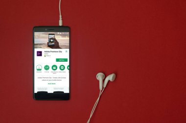 Los Angeles, 11 Ocak 2018: Smartphone ile Adobe premiere küçük uygulama google oyun deposunda bulunan kırmızı arka plan ile kulaklık takılı ve uzay kopyalama