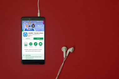 Los Angeles, 11 Ocak 2018: Smartphone ile google oyun uygulamada takılı kulaklık ile kırmızı zemin üzerine depolamak ve uzay kopyalamak ShareIt