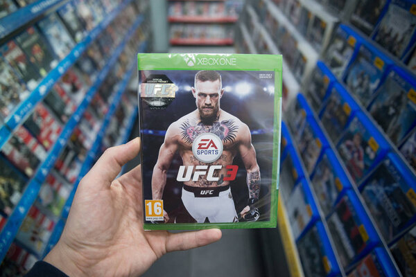 Bratislava, Slovakia, february 12, 2018: Man holding UFC 3 videogame on XBOX One console in store