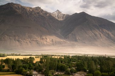 Tacikistan 'daki Pamir otoyolundaki köydeki dağlara bak.