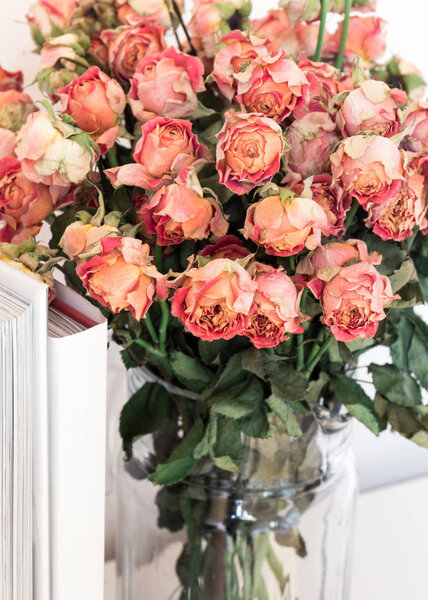 Withered bouquet of roses in a glass vase