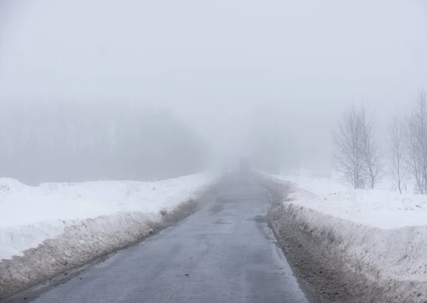 多雾的冬日 乡间沥青路 卡车在远方 — 图库照片