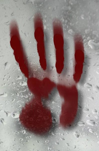 design with smeared blood red handprint on wet glass surface