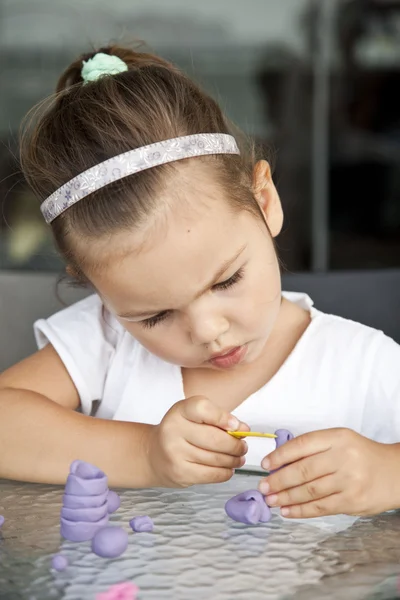 Little girl sculpts from clay — Stock Photo, Image