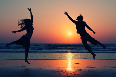 Romantik Çift günbatımında atlama