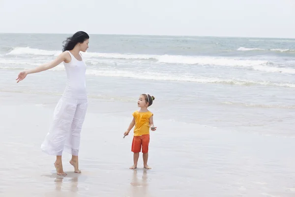 母と娘が浜を歩いている — ストック写真