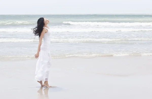 Donna in un prendisole bianco sulla costa — Foto Stock