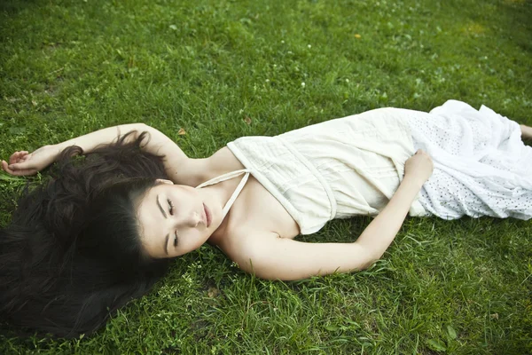 Fille couchée sur l'herbe verte — Photo