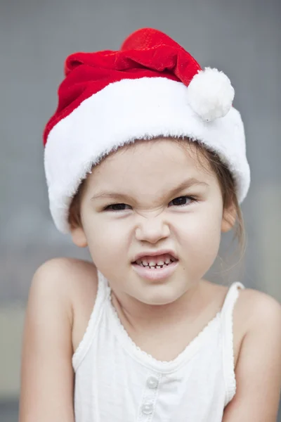 Emotional little girl in Santa Hat Stock Image