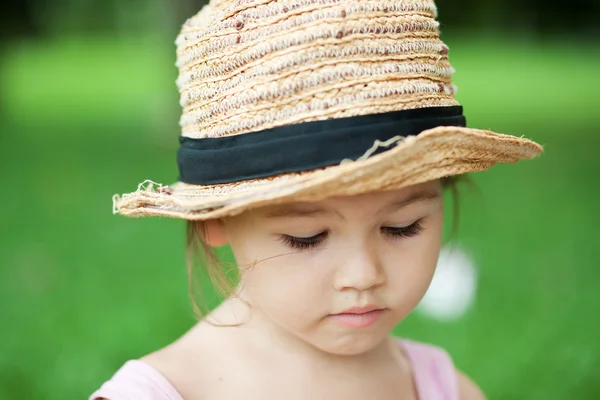 Meisje in een stro hoed in het park — Stockfoto