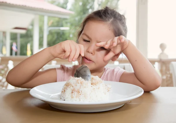 Маленькая девочка ест рис — стоковое фото