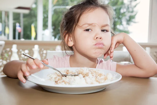 Маленькая девочка ест рис — стоковое фото