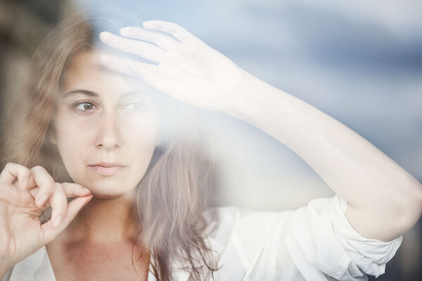 Melancholy reflection of the girl in the window