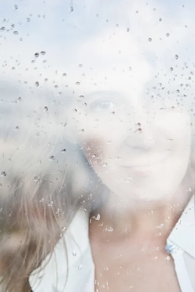 Меланхолическое отражение девушки в окне — стоковое фото
