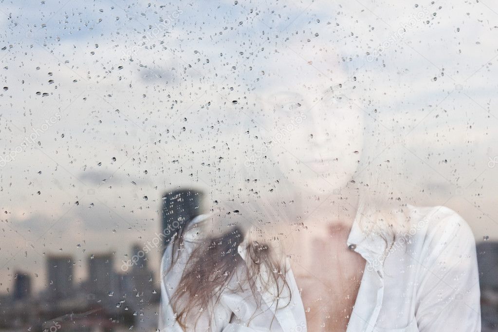 Melancholy reflection of the girl in the window