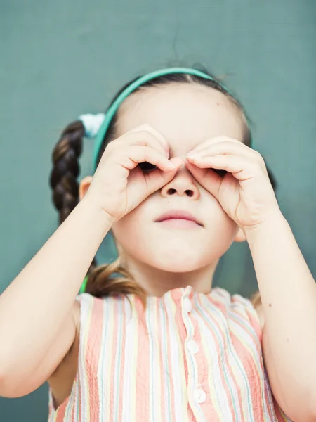 Girl looking into an imaginary binoculars — Stock Photo, Image