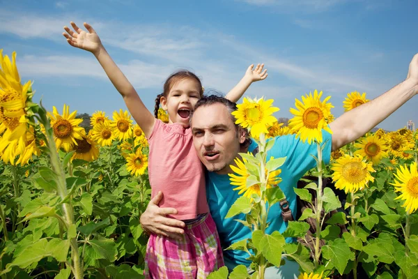 Familj på en promenad i solrosor fält — Stockfoto