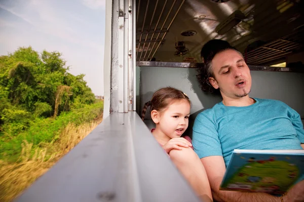 Família no trem lendo um livro — Fotografia de Stock