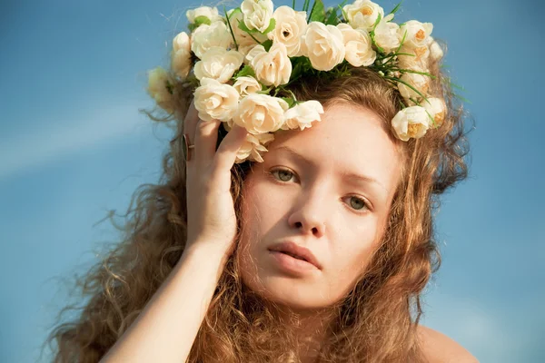 Flicka i en blomma krona — Stockfoto