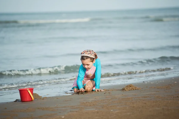 Meisje gebouw zandkasteel op het strand — Stockfoto