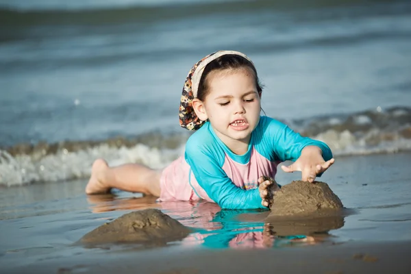 Dívka budování hrad z písku na pláži — Stock fotografie