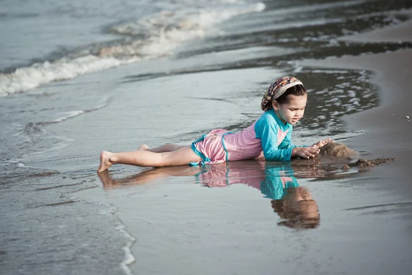 Meisje gebouw zandkasteel op het strand — Stockfoto