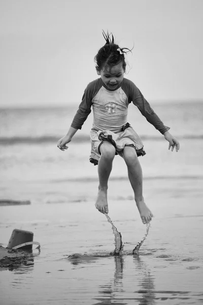 Flicka sitter på stranden — Stockfoto