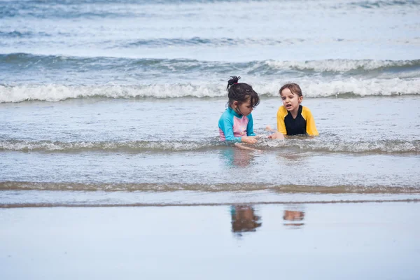 Маленькие девочки играют на пляже — стоковое фото