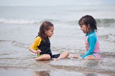 Kumsalda oynayan küçük kızlar