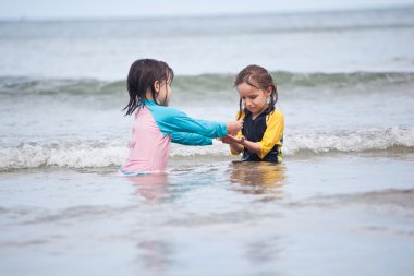 Kumsalda oynayan küçük kızlar