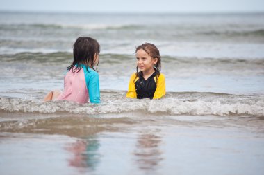 Kumsalda oynayan küçük kızlar