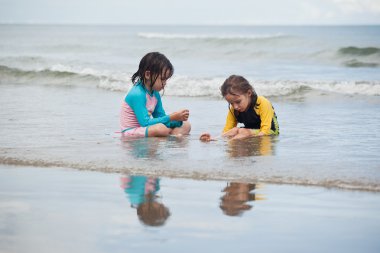 Kumsalda oynayan küçük kızlar