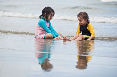 Kumsalda oynayan küçük kızlar