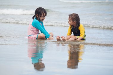 Kumsalda oynayan küçük kızlar