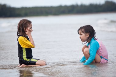 Kumsalda oynayan küçük kızlar
