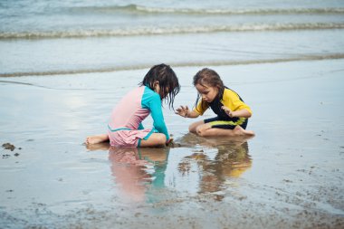 Kumsalda oynayan küçük kızlar