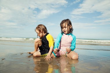 Kumsalda oynayan küçük kızlar