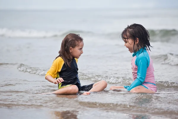 Kumsalda oynayan küçük kızlar