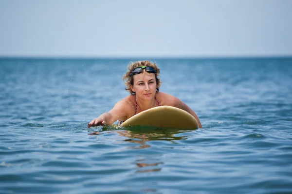 Frau schwimmt auf Brandung — Stockfoto