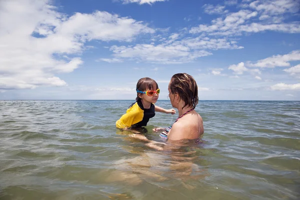 Mather ve denizde oynarken kızı — Stok fotoğraf